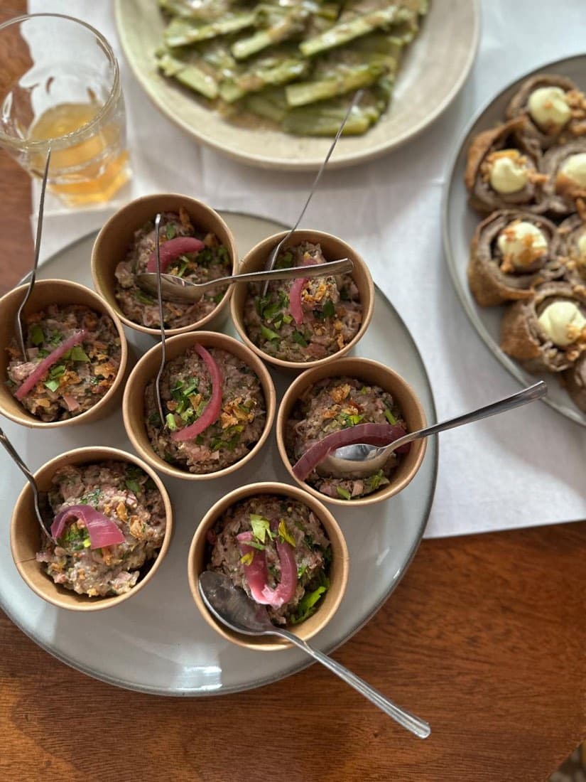Plateau de tartares servis en bols individuels avec oignon rouge mariné et herbes, à partager chez Ty Louis